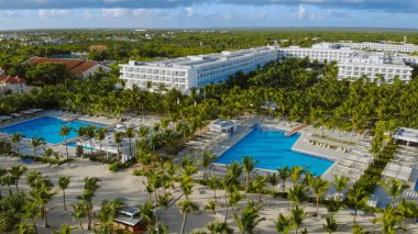 Aerial view of gigantic luxury Riu Republica Hotel Resort in Punta Cana during summer. Luxury pools and apartments with Ocean View. Aerial View Of Luxury Hotel With Outdoor Swimming Pool On Sunny Day.