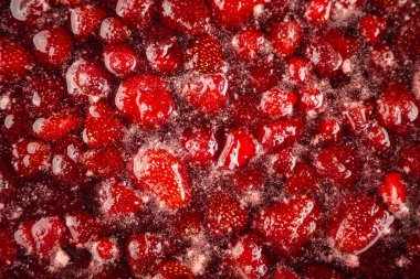 Ev yapımı çilek reçeli yapma süreci. Kırmızı tatlı şurup ocağın üstünde kaynıyor. Çilek reçeli çok iştah açıcı görünüyor. Ev yapımı çilek reçeli. Çilek reçeli pişiriyorum..