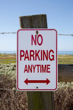 Dikenli tellerle çitlerde park yeri yok. Arka planda okyanus kıyısında park yeri yok. Dışarıda park yeri yok. Dikey düzenleme
