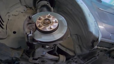 Yıpranmış disk freninin ayrıntıları yenilenmeye hazır. Direksiyonu sökmek için arabayı krikonun üzerine kaldır.
