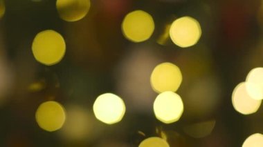 Odak arkaplanı dışında parıldayan bir Noel ağacı ışığını kapat. Süslemeleri ve aydınlatması olan yeni yıl ağacı. Xmas ağaç süslemeleri. Bulanıklıktan yumuşaklığa