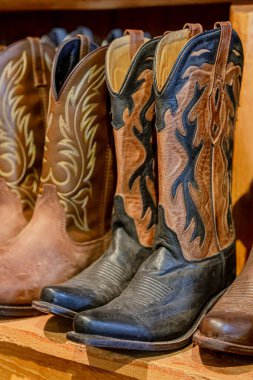 Kovboy çizmeleri hazır. Geleneksel Amerikan deri kovboy çizmeleri, batı tarzı, rodeo pazarı ve sergilenen binicilik malzemeleri. Devekuşu, timsah ve bufalo derisinden Amerikan tarzı botlar..