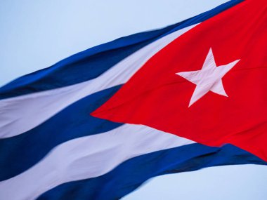 Bayrak direğinde dalgalanan Küba bayrağı, yaklaşın. Rüzgarda dalgalanan Küba bayrağı. Rüzgarda dalgalanan Küba bayrağına yakın plan temiz bir gökyüzü. Küba bayrağı tam çerçeve