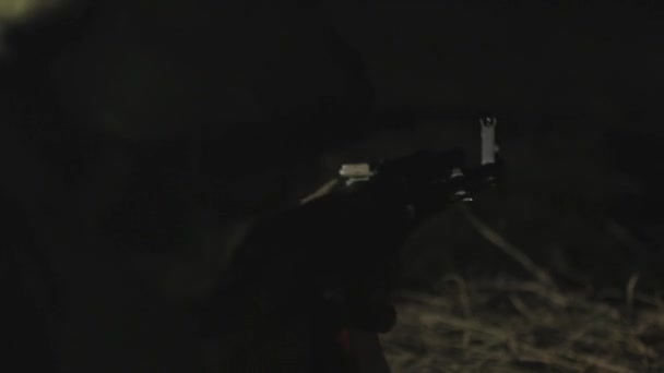 士兵在夜间用机枪向敌人射击 男兵把机枪对准近处 夜战在黑暗背景下从机枪上射击 — 图库视频影像