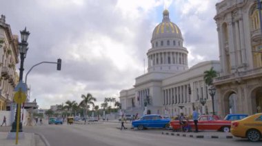 Havana şehrinin hayatı. Havana, Küba 'nın ana caddesi, klasik Amerikan arabaları Küba, Havana' daki Ulusal Kongre binası yakınlarındaki caddelerden geçiyor. Eski Havana, Küba 'da sokakta Amerikan klasik arabaları