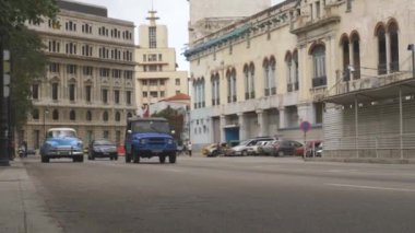 Havana Şehir Hayatı. Havana 'nın eski yoksul bölgesinde balkonlu eski evler, dar kirli sokaklar, eski arabalar, yoldan geçenler ve yürüyen turistler. Havana, Küba - 10 Ocak 2022