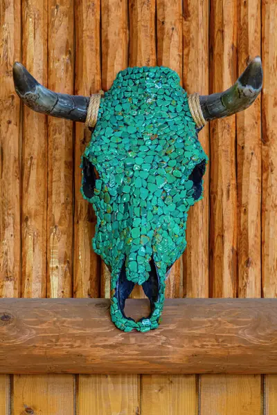 Decorated Cow skull wall sculpture with semi-precious gemstones of Turquoise on wooden background. Navajo Native American Indian, handcrafted work of art Turquoise Steer Bull Skull.Decorated cow skull