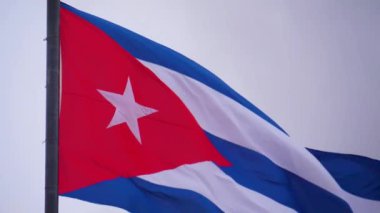 Küba Bayrağı Ağır çekim Dalgalanması. Rüzgarda dalgalanan Küba bayrağı. Rüzgarda dalgalanan Küba bayrağına yakın plan temiz bir gökyüzü. Küba bayrağı Dramatik sinematik görünüş, yavaş çekim, alt görünüm