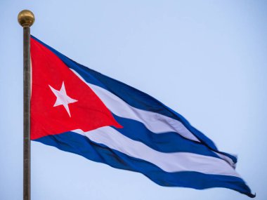 Küba 'nın kalbinde büyük bir bayrak, Havana. Bayrak direğinde dalgalanan Küba bayrağı, alt manzara. Rüzgarda dalgalanan Küba bayrağı. Rüzgarda dalgalanan Küba bayrağına yakın plan açık bir gökyüzü.