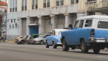 Havana, Küba - 10 Ocak 2022 - Küba, Havana 'nın yoksul bir bölgesinde dar bir cadde boyunca eski bir retro araba sürüyor. Retro Amerikan arabaları Küba 'nın başkentini ziyaret ediyor. Havana 'da trafik vardı.