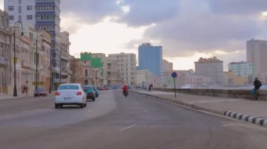 Havana, Küba - 10 Ocak 2022 Havana Küba seti yolu ve şehir merkezinde ufuk çizgisi olan şehir binasında Malecon 'u gezdirmek. Malecon 'da yüksek dalgalar deniz duvarına çarpıyor. Malecon 'da gün batımı