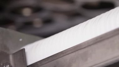 Plastik kaplar konveyör boyunca yavaşça hareket ediyor. Plastik konteynırlar plastik üretim tesisinde konveyör boyunca hareket ediyorlar. Enjeksiyon kalıplı plastik tepsiler istifleniyor. Kapat.