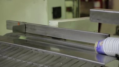 Plastik kaplar mekanik olarak taşıyıcıdan çıkarılıyor. Plastik kaplar konveyör boyunca yavaşça hareket ediyor. Yeni yapılmış plastik kaplar gruplar halinde hareket ediyor..