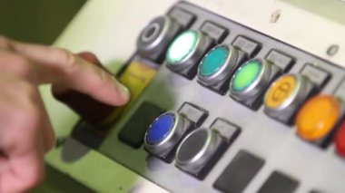 İnsan eli fabrikadaki kontrol paneline basıyor. İşçi yönetim makinesi düğmelere basıyor. Kontrol panelindeki makinenin üretim sürecini kontrol eden mühendis. Fabrikanın kapanış paneli.
