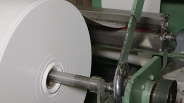 Fabrika ortamında gelişmiş bir endüstriyel makinede önemli miktarda plastik makara. Gelişmiş teknoloji ve verimli makinelerle modern plastik rulo imalatı.