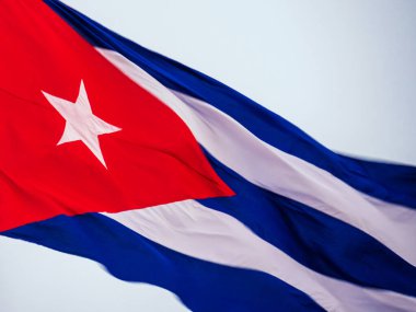 Bayrak direğinde dalgalanan Küba bayrağı, yaklaşın. Rüzgarda dalgalanan Küba bayrağı. Rüzgarda dalgalanan Küba bayrağına yakın plan temiz bir gökyüzü. Küba bayrağı tam çerçeve