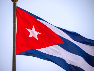 Bayrak direğinde dalgalanan Küba bayrağı, yaklaşın. Rüzgarda dalgalanan Küba bayrağı. Rüzgarda dalgalanan Küba bayrağına yakın plan temiz bir gökyüzü. Küba bayrağı tam çerçeve