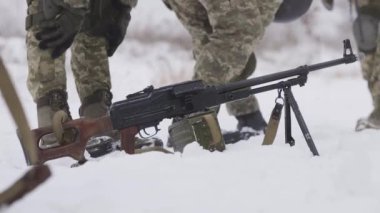 Asker hafif bir makineli tüfekle göreve gider. Bir özel kuvvetler grubu kışın özel bir operasyona hazırlanıyor. Arkaplandaki kara karşı bir makineli tüfek. Kış Askeri Özel Operasyon