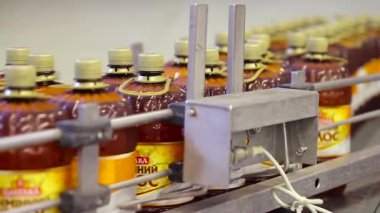 Poltava, Ukrayna - Temmuz 2017: Taşıyıcıda kahverengi plastik şişelerde bira. Bira fabrikasında bira şişeleme alışverişi. Bira fabrikasındaki bira şişelenmiş ve etiketlenmiş. Bira şişeleme ve paketleme alışverişi..