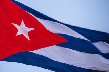 Bayrak direğinde dalgalanan Küba bayrağı, yaklaşın. Rüzgarda dalgalanan Küba bayrağı. Rüzgarda dalgalanan Küba bayrağına yakın plan temiz bir gökyüzü. Küba bayrağı tam çerçeve