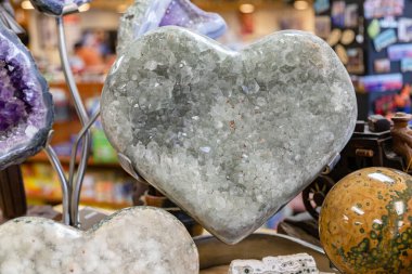 Gemstone 'un kalbi beyaz akik ile oyuluyor. Hediyelik eşya dükkanında parlak kalp heykelciği. Yüksek parlatıcılı kalp heykeli. Beyaz şeffaf taş ince şeritleri ortaya çıkarır. Hediyelik eşya dükkanı