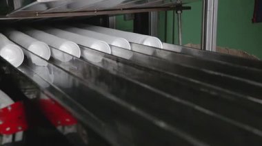Plastik konteynır üretim hattı termoform işlemini gösteriyor. Beyaz plastik kaplar plastik çarşafları ısıtıp şekillendiriliyor. İşlem yüksek verimlilik için otomatikleştirildi