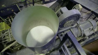 Sanayi plastik geri dönüşüm fabrikası polietilen atığı işliyor. Makineler geri dönüştürülmüş malzemeleri plastik poşetlere dönüştürüyor. Taşıyıcı sistemler üretim aşamaları boyunca işlenmiş pulları taşır.