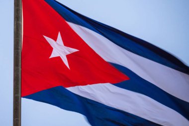 Bayrak direğinde dalgalanan Küba bayrağı, yaklaşın. Rüzgarda dalgalanan Küba bayrağı. Rüzgarda dalgalanan Küba bayrağına yakın plan temiz bir gökyüzü. Küba bayrağı tam çerçeve