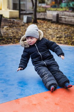Düşen çocuk şişme bir trambolinde yan düşüşü gerçekleştirir. Hava fedaisinin üzerinde kanat çırpan bir çocuğun yumuşak düşüşü güvence ve koruma sağlar. Yumuşak düşüş güvenlik ve güvenlik kavramını vurguluyor