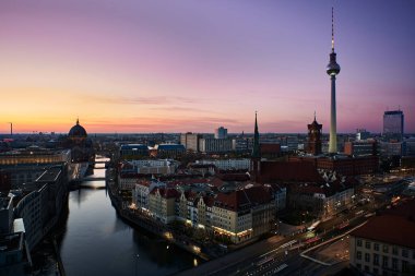 Berlin, Almanya 17 Nisan 2022 - Friedrichswerder Mahallesi 'nde gün batımında Berlin şehir merkezinin yüksek panoramik manzarası. Berlin merkez bölgesinde alacakaranlık. Uzun Fernsehturm Nehri 'nin üzerinden yükseliyor. Spree Nehri.
