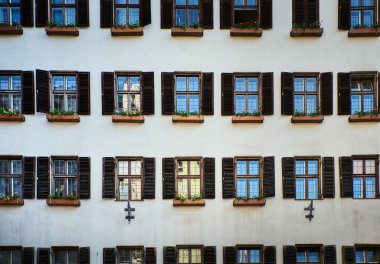 Innsbruck 'ta tahta külüstür ve çiçek desenli açık eski pencere desenli eski bina cephesi. Tarihsel mimari ya da ortaçağ dış görünüşü açık kereste panjurları ya da daha yüksek sesli. Avusturya