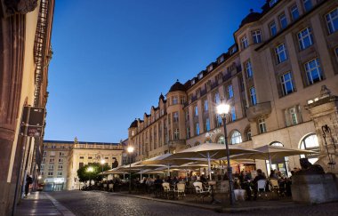 Leipzig, Almanya, 14 Mayıs 2022 - Leipzig, Saksonya bölgesinde, sıcak bir yaz gününde Naschmarkt 'ta dışarıda oturan insanlarla birlikte. İnsanlar Leipzig 'deki Lwenbrunnen çeşmesinin yanındaki Nasch Meydanı' nda takılıyor.
