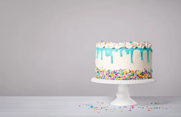 香草奶油生日蛋糕 带有茶色的蓝色心绞痛滴注和白色背景的彩色洒水 时髦的 复制空间 — 图库照片
