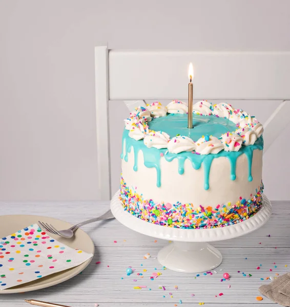 生日宴会的背景是香草奶油蛋糕 茶色的蓝色心绞痛滴 点燃的金色蜡烛 以及浅灰白色背景的彩色洒水 复制空间 — 图库照片