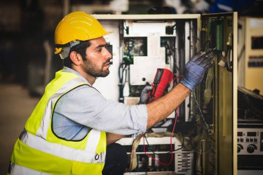 Elektrik mühendisi, endüstriyel üretim için elektrik kabin kontrolünde voltaj ve elektrik akımını ölçen bir testçi..