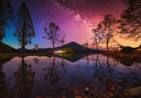 Landscape with Milky way galaxy. Mt. Fuji over lake with big trees and milky way at sunrise in Fujinomiya, Japan.