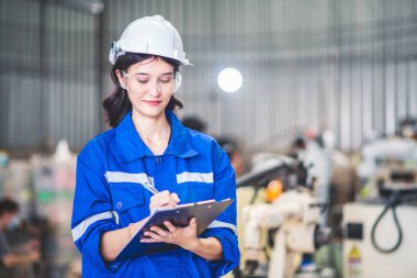 Çelik fabrikası atölyesinde çalışan kadın mühendisler. Otomatik üretim teknolojisi için endüstriyel robot programlama yazılımı