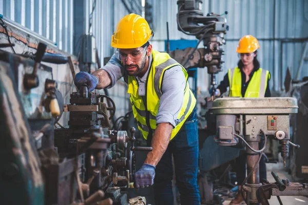 Ağır endüstri işçilerinin portresi çelik yapı endüstrisi için bir makinede torna işleterek metal üretim süreci üzerinde çalışıyor..