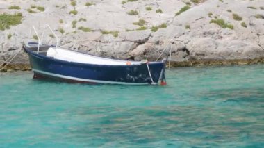 Kissamos, Yunanistan - 15 Temmuz 2022: Dünyanın en temiz plajlarından birine sahip dünyaca ünlü Ballos Körfezi. Kıyıdaki Girit Denizi 'nin şeffaf turkuaz suyu ve bir balıkçı teknesi..