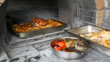 Gerçek bir fırından taze pişmiş yemekler. Kızarmış tavuk butları, doldurulmuş domates, biber ve haşlanmış patates. Ulusal Yunan mutfağı.
