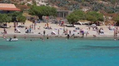 Kissamos, Yunanistan - 15 Temmuz 2022: insanlar dünyanın en temiz plajlarından birine sahip dünyaca ünlü Ballos Körfezi 'nde yüzer, güneşlenir ve dinlenirler. Girit Denizi 'nin şeffaf turkuaz suyu.