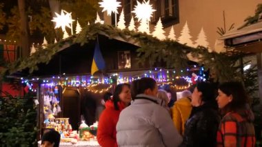 25 Kasım 2022 - Offenburg, Almanya: Geceleri Noel pazarı, Ukrayna çadırı çeşitli vatanseverlik hatıraları ve yiyecekleri olan, insanların tatillerini geçirdikleri.
