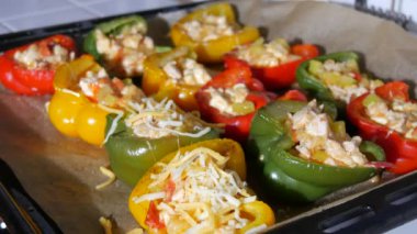 Kadınların elleri üzerine doğranmış peynir serpiştirir. Paprika yarım sarı, kırmızı, yeşil leziz. Üstünde fırından yeni çıkmış peynirle pişirilmiş et ile doldurulur..