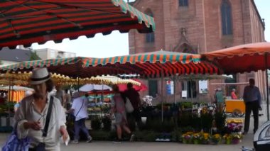 Kehl, Almanya - 26 Temmuz 2022: Pazarın çadırlarla ve ürünlerle yer aldığı yaz pazar meydanı, alıcılar malların yanından geçiyor.