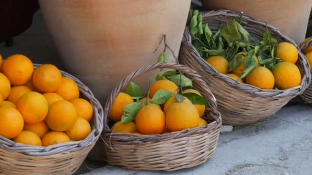 街上的市场上 躺着有绿色枝干的成熟橙子 人们走过 — 图库视频影像
