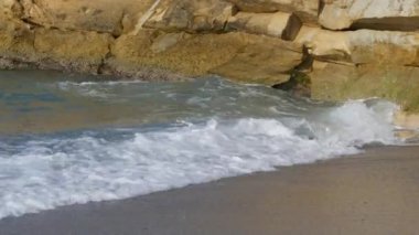Denizde fırtına. Girit Denizi 'ndeki bir yaz fırtınası sırasında köpüklü güzel ve güçlü dalgalar. Dalgalar kayalara çarpar..