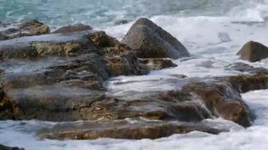 Denizde fırtına. Girit Denizi 'ndeki bir yaz fırtınası sırasında köpüklü güzel ve güçlü dalgalar. Dalgalar kayalara çarpar..