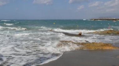 Denizde fırtına. Girit Denizi 'ndeki bir yaz fırtınası sırasında köpüklü güzel ve güçlü dalgalar. Dalgalar kayalara çarpar..