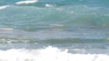 Denizde fırtına. Girit Denizi 'ndeki bir yaz fırtınası sırasında köpüklü güzel ve güçlü dalgalar. Dalgalar kayalara çarpar..