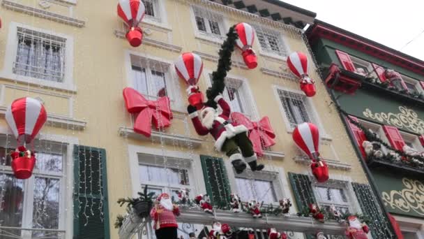 新年の休日の装飾を背景に家の上に大きな移動クリスマスのおもちゃサンタクロースの装飾 — ストック動画